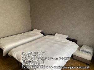 two beds in a room with at 夕食ご用意可能guesthouse Yokomachi 街の中心部 静かな通りの一棟貸切 in Shingū