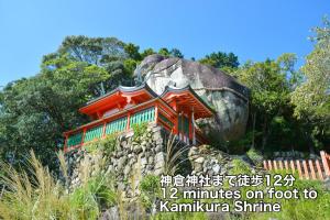 a building on top of a rock at 夕食ご用意可能guesthouse Yokomachi 街の中心部 静かな通りの一棟貸切 in Shingū