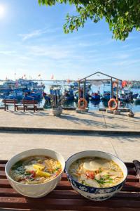 two bowls of food sitting on a wooden table at Hoa Bien Motel in Ly Son