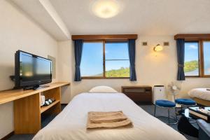 a room with a bed and a flat screen tv at Hotel Sol at Lake Toya in Lake Toya