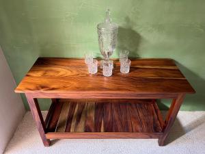 a wooden table with four glasses on top of it at T'uut' Hotel in El Cuyo