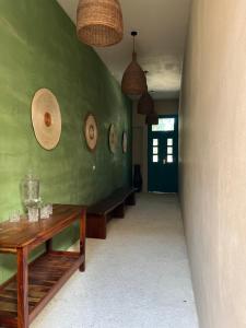 a room with a green wall with a wooden table at T'uut' Hotel in El Cuyo
