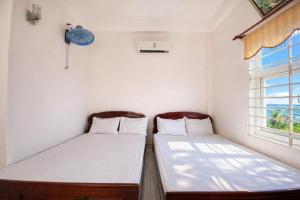 two beds in a small room with a window at Hoa Bien Motel in Ly Son