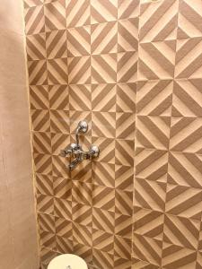 a bathroom with a tiled wall with a toilet at Hotel RK Palace Vrindavan - Near Bankey Bihari and Prem Mandir in Vrindāvan +31 photos