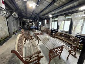 a group of benches and a table in a room at Wangyuku B&B in Jiufen