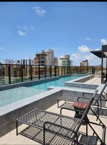 a balcony with a table and chairs and a swimming pool at Flat Azzure 205 in Cabedelo