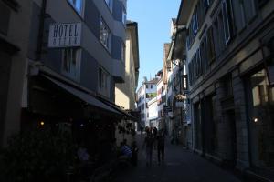 a group of people walking down a street at Oldtown Hostel Otter in Zurich