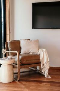 a brown leather couch in a living room with a table at 3 Acres by the Moyne in Port Fairy