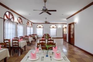 a dining room with tables and chairs and pink decorations at Domi Hotel in Siem Reap