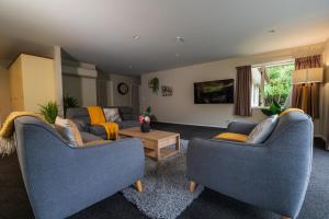 a living room with two couches and a table at Rainforest Retreat in Franz Josef