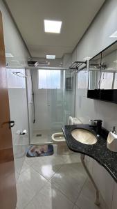 a bathroom with a shower and a sink and a toilet at Apartamento no Centro 2 Wi-Fi Garagem in Vacaria +28 photos