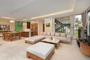 a living room with a couch and a television at Diamond Beach Villa Da Nang in Danang