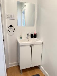a white bathroom with a sink and a mirror at A home in Niagara falls- The Maple and Mist in Niagara Falls