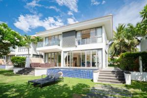 a large white house with a pool and yard at Diamond Beach Villa Da Nang in Danang
