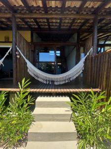 a wooden walkway with a white rope hanging from a building at Flats Bon Voyage Caboré - Chez Cira in Paraty