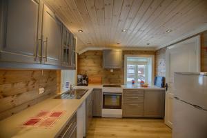 a large kitchen with wooden walls and a wooden floor at Modern Comforts, and Ski Access in Beitostøl