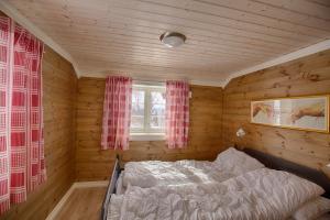 a bedroom with a bed in a room with wooden walls at Modern Comforts, and Ski Access in Beitostøl