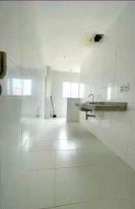 a white room with a sink and a white tile floor at Apto 204 in Barcarena