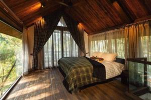 a bedroom with a bed in a room with windows at Amaya Retreat in Sóc Sơn