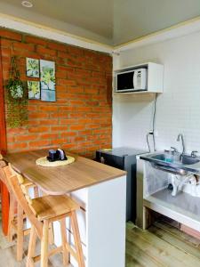 a kitchen with a wooden table and a brick wall at Apartaestudio Queremal in Papagalleros +11 photos