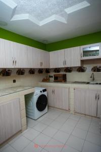 a kitchen with a washer and dryer in a room at Cabral residence in Guediawaye