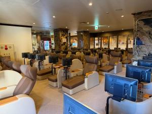 a salon with a waiting room with chairs and televisions at Capsule Hotel Sauna G -topia male Only in Funabashi