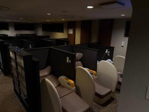 a waiting room with chairs and tables in a room at Capsule Hotel Sauna G -topia male Only in Funabashi