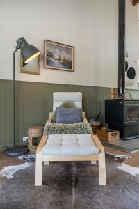 a bed sitting in a room with a lamp at Mara Luxe Farm Stay 20 mins from Beach in Forster