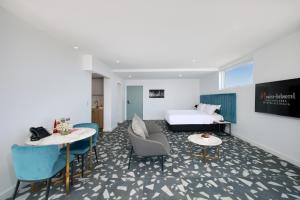 a hotel room with a bed and two tables and chairs at Swiss-Belhotel Woolloongabba, Brisbane in Brisbane