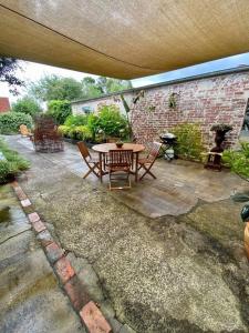 a patio with a table and chairs and a brick wall at Lydiard General Cafe Delight in Ballarat