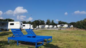 a group of blue chairs sitting in a field with trailers at Seogwipo PyoseonCaravan in Seogwipo +10 photos
