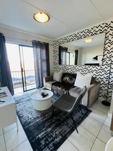 a living room with a couch and a mirror at Lagoon Aparthotel in Pretoria