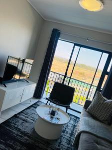 a living room with a couch and a large window at Lagoon Aparthotel in Pretoria
