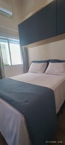 a bedroom with a large bed with blue walls at Casa Belíssima in Pelotas