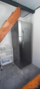 a kitchen with a stainless steel refrigerator in a room at Casa Belíssima in Pelotas