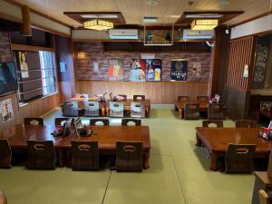 a dining room with wooden tables and chairs at Capsule Hotel Sauna G -topia male Only in Funabashi