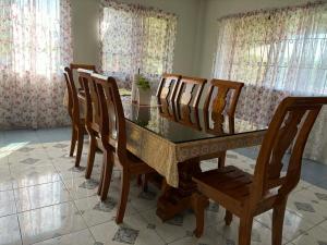 a dining room with a glass table and wooden chairs at Pableo's Pension House in Moalboal in Moalboal +22 photos