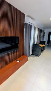 a living room with a large television on a wall at Lakambini Transient in El Nido