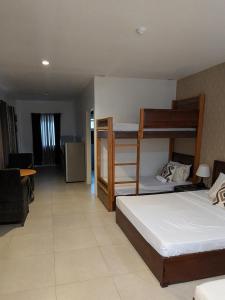 a bedroom with two bunk beds and a living room at Lakambini Transient in El Nido +2 photos