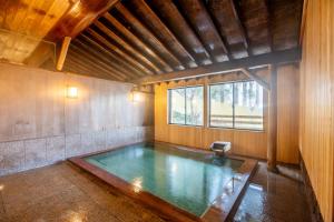 ein Wasserbecken in einem Raum mit Fenster in der Unterkunft 源泉の湯 福の屋 in Minakami
