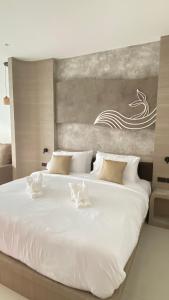 a large white bed in a bedroom with a painting at Mermayda pool villa hatyai -เมอเมดา in Hat Yai +12 photos