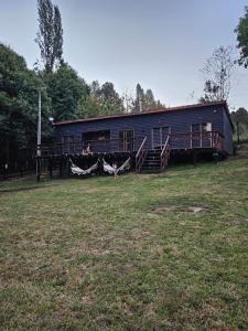 a large black building with people on it in a field at Casa en Panguipulli in Neltume