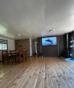 a living room with a table and a tv on a wall at Casa en Panguipulli in Neltume
