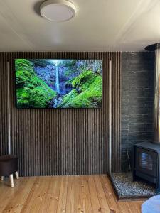 a room with a tv on a wall with a fireplace at Casa en Panguipulli in Neltume
