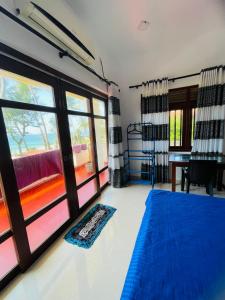 a bedroom with a blue bed and a desk at Hotel Meer in Ambalangoda