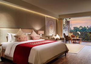 a bedroom with a large bed and a balcony at Goya Boutique Resort in Ubud