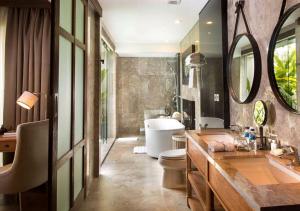 a bathroom with a tub and a toilet and a sink at Goya Boutique Resort in Ubud +123 photos
