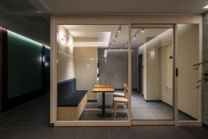 a meeting room with a table and a bench at Brown Dot Hotel Siheung Geobukseom in Siheung