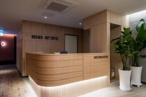 an office lobby with a reception desk withcriptions on the wall at Brown Dot Hotel Siheung Geobukseom in Siheung