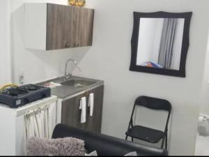 a kitchen with a sink and a mirror and a chair at Habitación de Lujo para Pareja in Darién